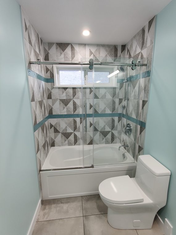 Bathtub set under a patterned tile shower surround
