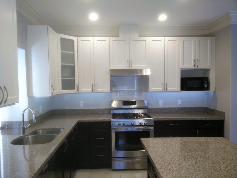 White kitchen with a stainless range and stone counters