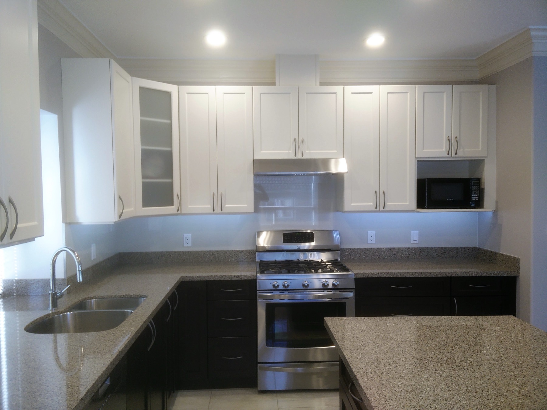 White kitchen with a stainless range and stone counters