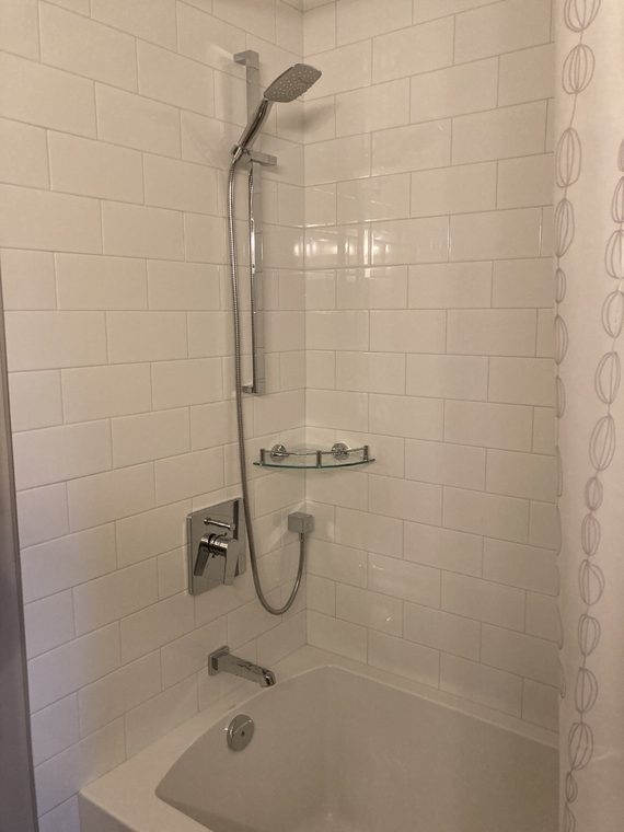 Tiled shower with a fixed head and handheld on a rail