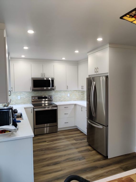 White kitchen with stainless appliances and a breakfast bar